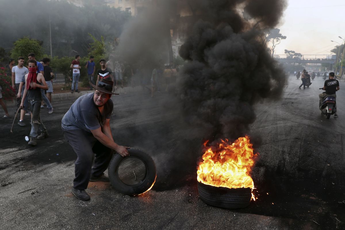 Protesters burn tires to block a road, in Beirut, Lebanon, Thursday, June 24, 2021. Dozens of angry protesters, angered by deteriorating living conditions and government inaction, partially blocked Beirut