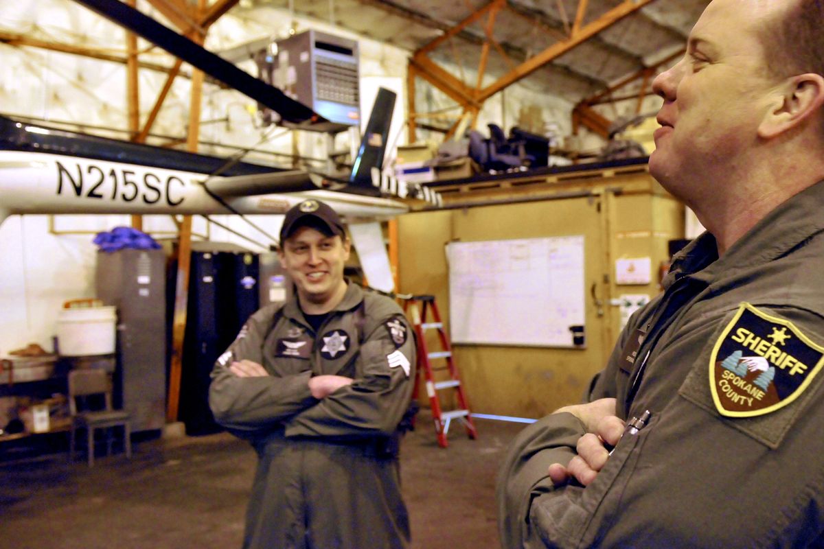 Sgt. Dave Ellis, left, and pilot Lt. Col. Rod Melzer talk about some of the successes of Air 1, the Spokane County Sheriff’s Office helicopter, on Thursday at a Felts Field hangar. Melzer, an Air Force officer, is one of eight volunteer pilots who fly Air 1. (PHOTOS BY JESSE TINSLEY)