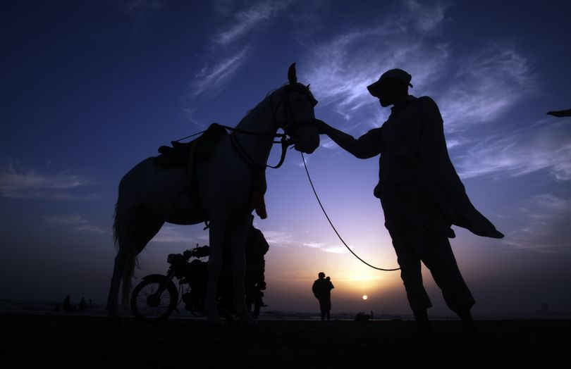 A Pakistani owner waits for customers for a horse ride to earn his living at Clifton beach in Karachi, Pakistan, Tuesday, May 3, 2016. People visit beaches in evening during a summer in Karachi. (Shakil Adil / Associated Press)