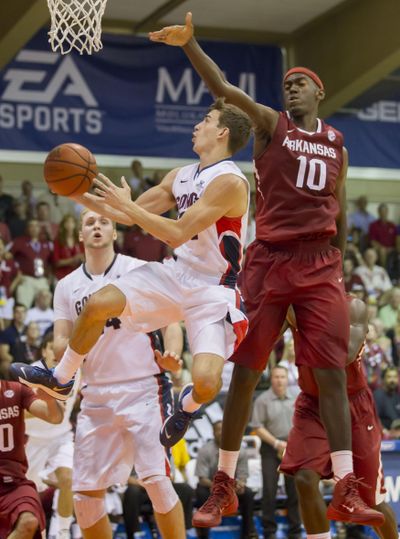 Gonzaga guard David Stockton (11) darts under Arkansas forward Bobby Portis (10) to shoot a layup while his teammate center Przemek Karnowski, back left, looks on in the first half of an NCAA college basketball game at the Maui Invitational on Wednesday, Nov. 27, 2013, in Lahaina, Hawaii. (Eugene Tanner / AP)