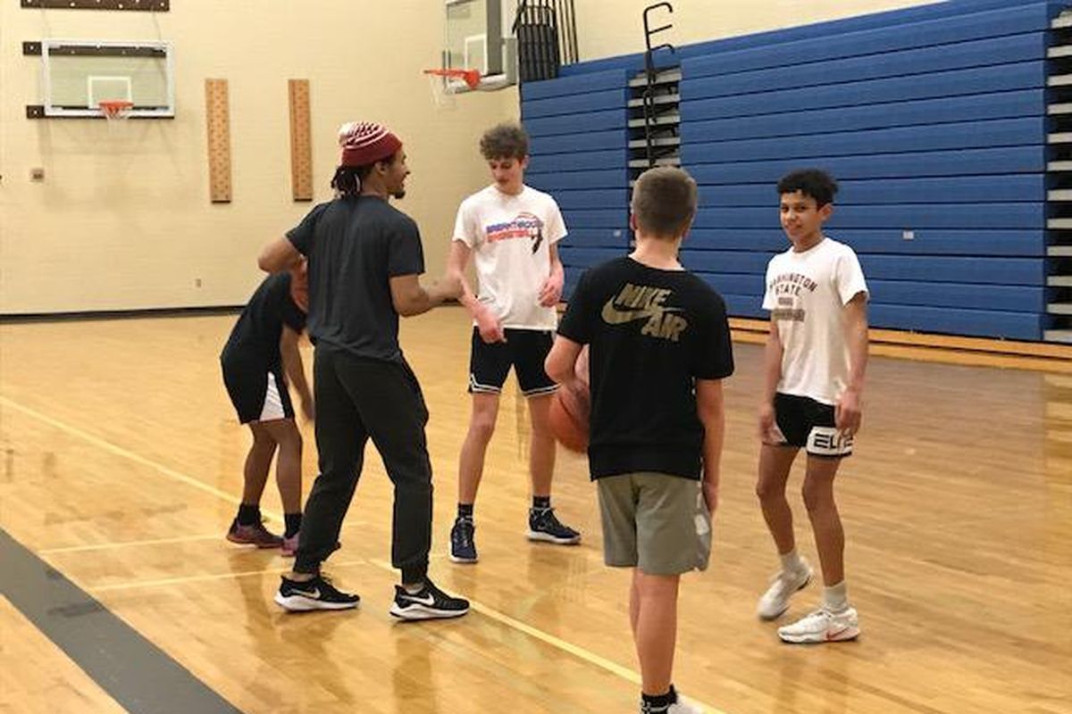 Washington State guard Isaac Bonton (in hat) coaches the eighth-grade Pullman Titans AAU basketball team during a practice on Feb. 11, 2020, in Pullman. (Theo Lawson / The Spokesman-Review)