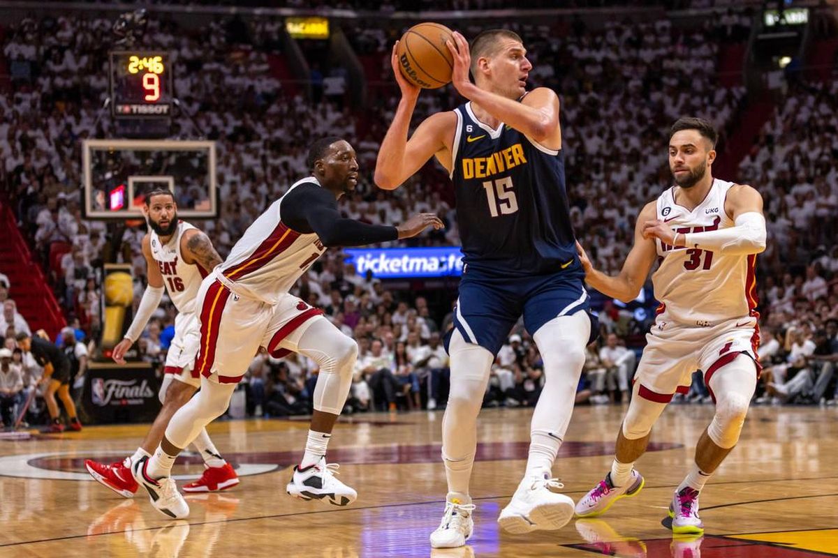 Denver center Nikola Jokic looks to pass Friday while defended by Miami forward Max Strus during the first half of Game 4 of the NBA Finals in Miami.  (Tribune News Service)