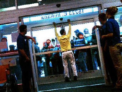 Employees of Best Buy prepare to let in about 60 people lined up for their chance at the new Microsoft Xbox 360 game system, which was released on Tuesday.
 (The Spokesman-Review)