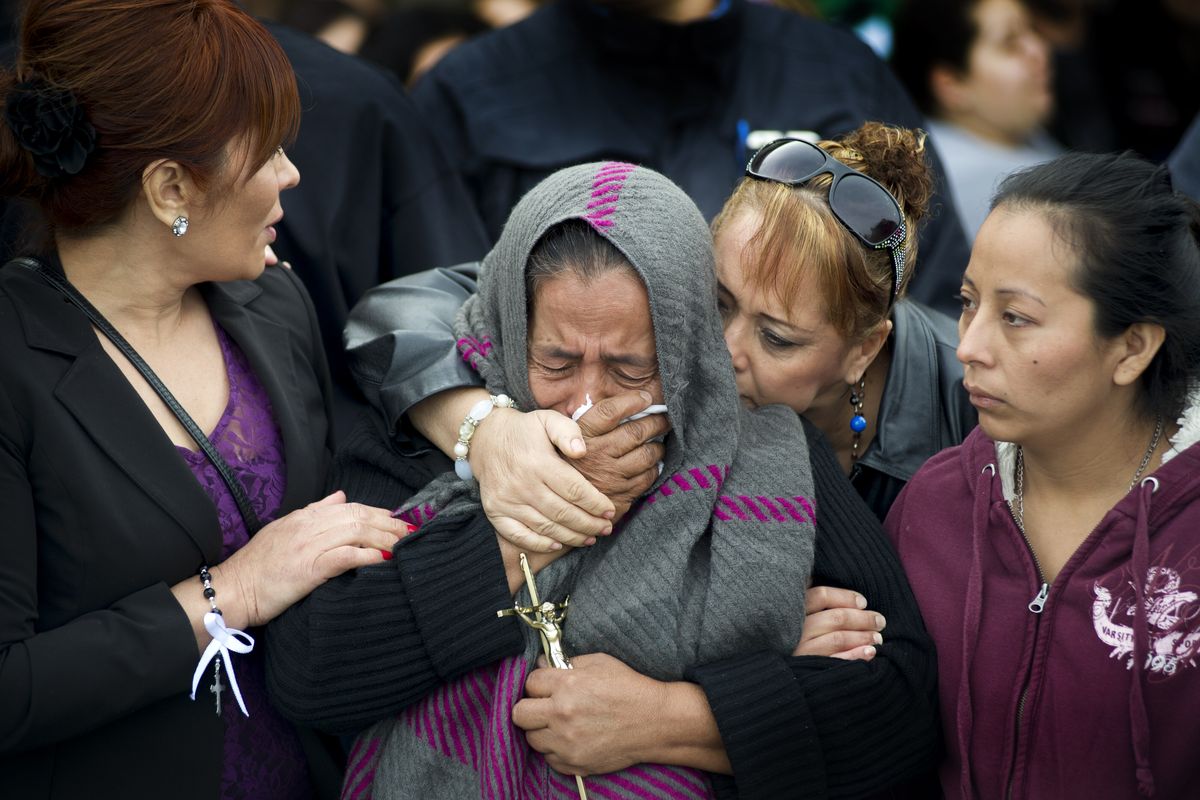 Agapita Montes-Rivera, center, the mother of Antonio Zambrano-Montes, is comforted as she weeps with her daughter Rosa Elena Zambrano-Montes, far right, as his casket is brought from his funeral Mass to a hearse at St. Patrick’s Catholic Church in Pasco in 2015. (Tyler Tjomsland / The Spokesman-Review)