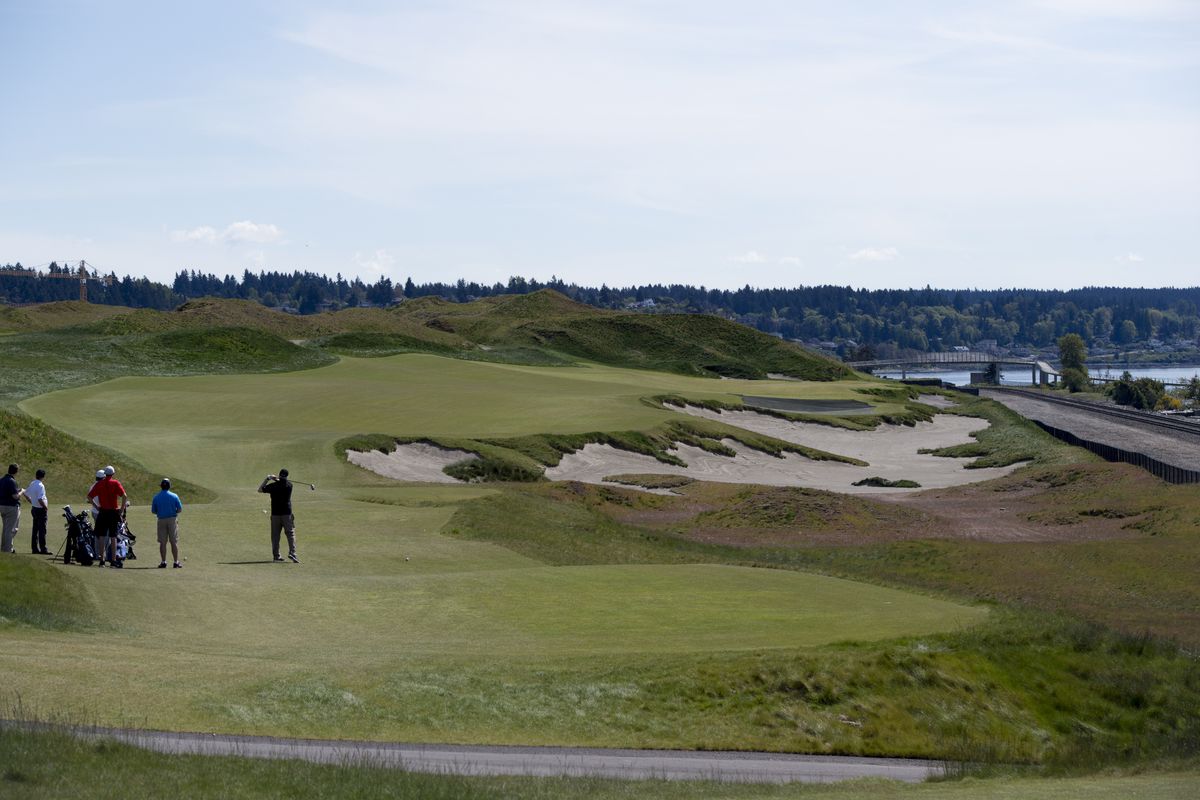 Golfers drive through the third hole of Chambers Bay Golf Course on April 27 in University Place, Washington. (Tyler Tjomsland)