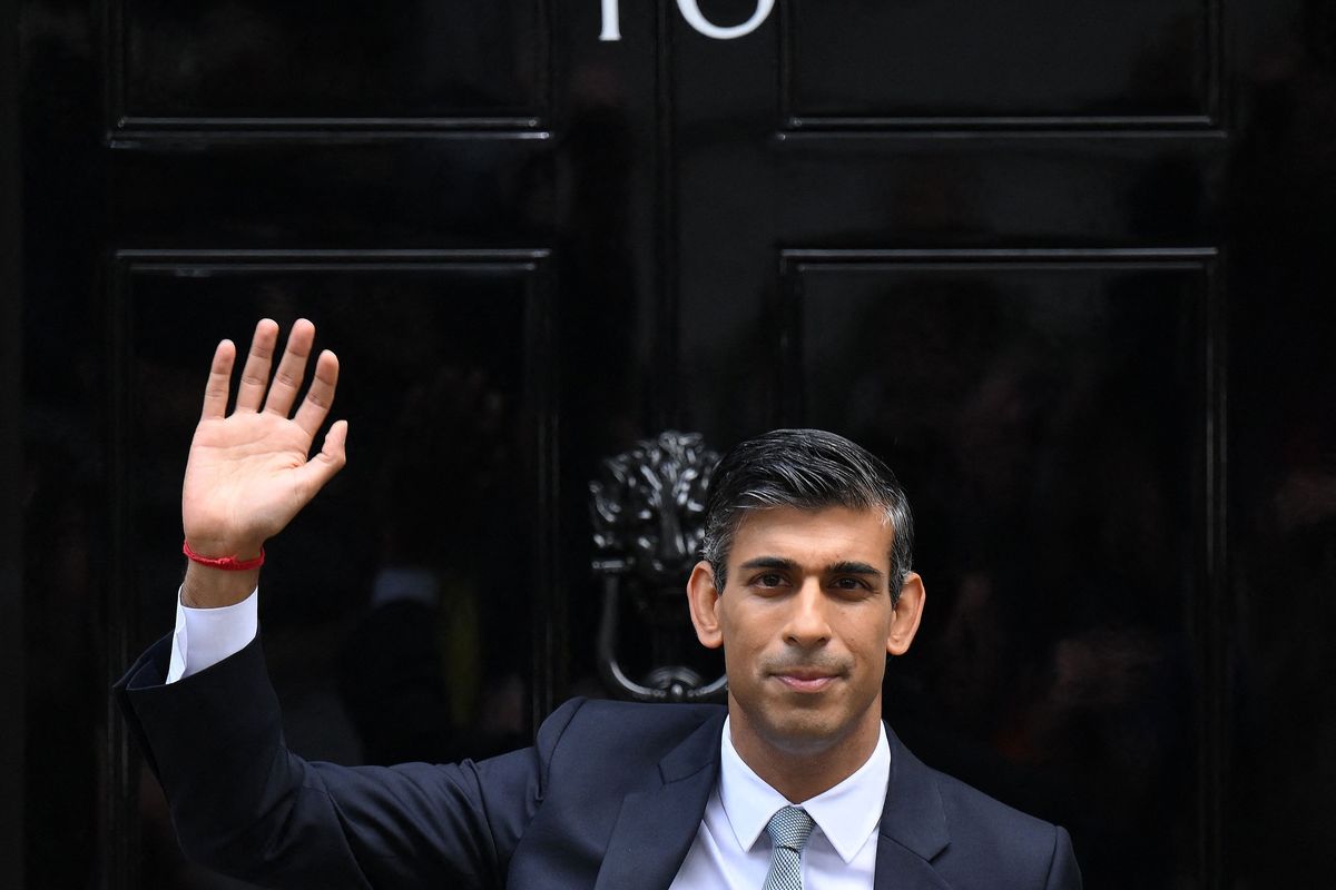 Britain's newly appointed Prime Minister Rishi Sunak waves as he poses outside to door to 10 Downing Street in central London, on October 25, 2022, after delivering his first speech as prime minister. - Rishi Sunak was on Tuesday appointed as Britain's third prime minister this year after outgoing leader Liz Truss submitted her resignation to King Charles III.    (DANIEL LEAL/Getty Images North America/TNS)