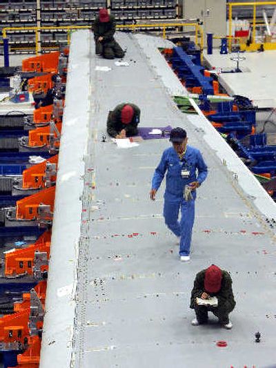 
Workers work on a main wing of a Boeing 787 at Mitsubishi Heavy Industries' factory in Nagoya, Japan, on Monday. 
 (Associated Press / The Spokesman-Review)