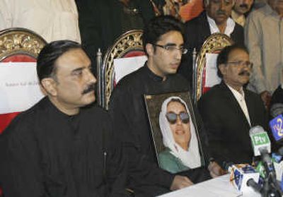 
Bilawal Zardari, son of Benazir Bhutto, holds a photo of his mother at a news conference Sunday with his father, Asif Ali Zardari, left, and party leader Amin Fahim in Naudero.Associated Press
 (Associated Press / The Spokesman-Review)