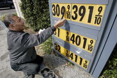 
Gas station attendant Toke Fusi puts up higher gas prices for self-service at Menlo-Atherton Shell gas station in Menlo Park, Calif., on Wednesday. The right side shows full-service gas prices. Associated Press
 (Associated Press / The Spokesman-Review)