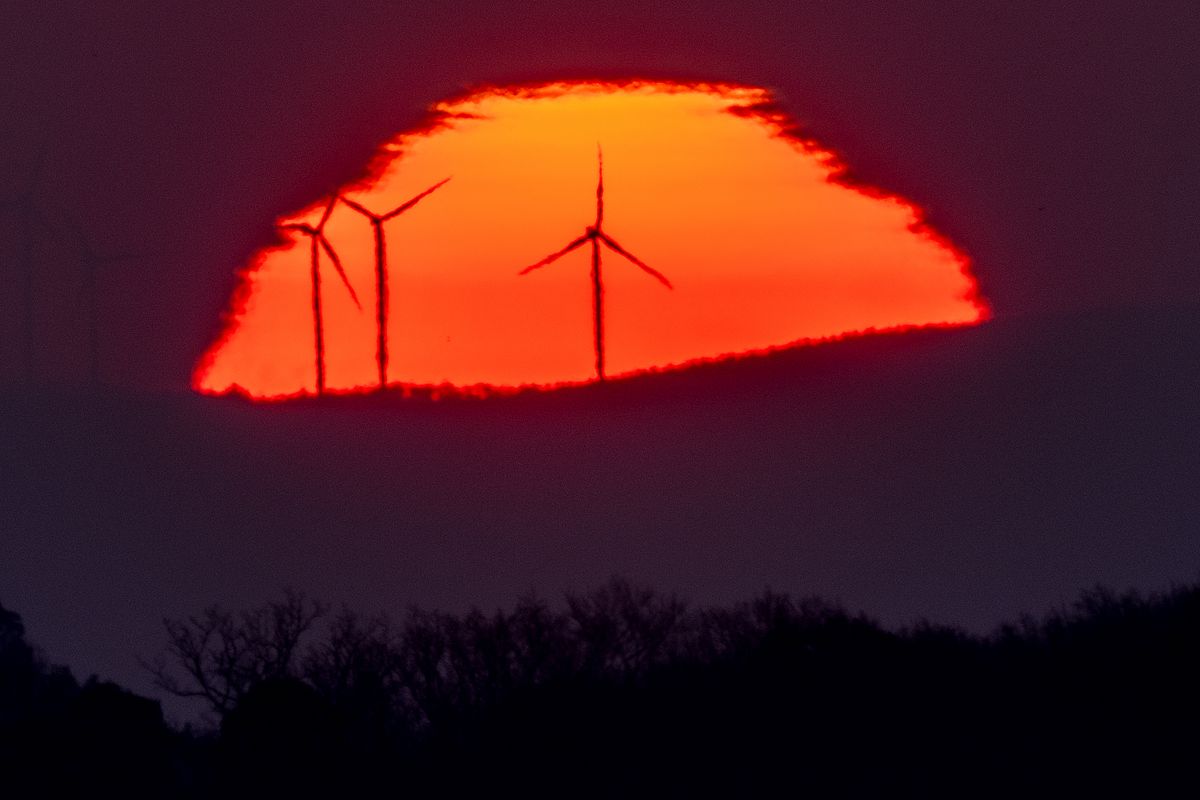 FILE - Wind turbines stand in front of the rising sun in Frankfurt, Germany, Friday, March 11, 2022. A United Nation-backed panel plans to release a highly anticipated scientific report on Monday, April 4, 2022, on international efforts to curb climate change before global temperatures reach dangerous levels.  (Michael Probst)