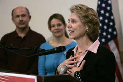 
Christine Gregoire speaks to reporters Wednesday in Seattle as her husband, Mike, and daughter, Courtney, stand behind. 
 (Associated Press / The Spokesman-Review)