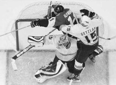 Senators' Daniel Alfredsson, top left, gets jammed into the net as he scores a goal Saturday.
(Associated Press / The Spokesman-Review)