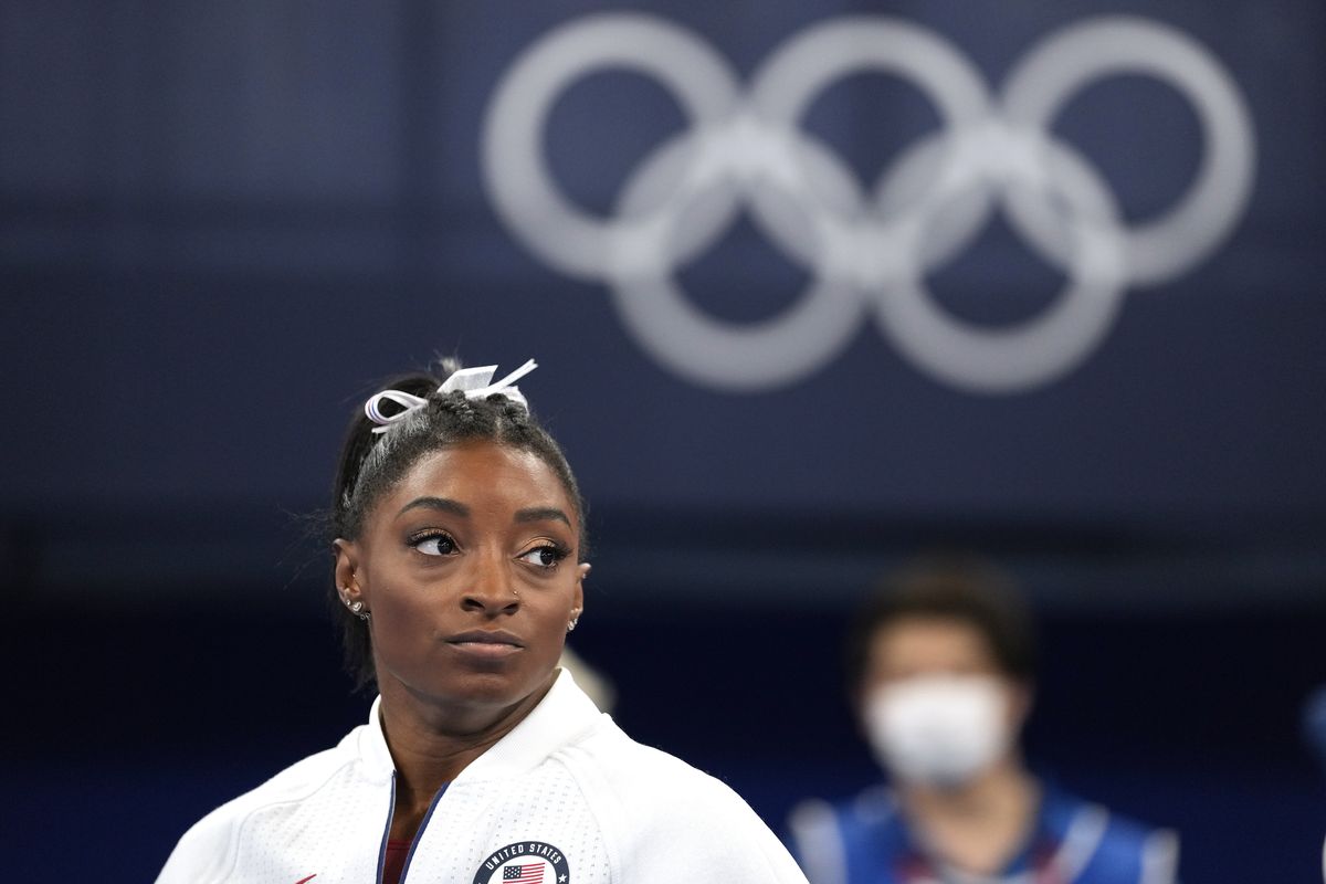 Simone Biles, of the United States, watches gymnasts perform after she exited the team final with apparent injury, at the 2020 Summer Olympics, Tuesday, July 27, 2021, in Tokyo. The 24-year-old reigning Olympic gymnastics champion Biles huddled with a trainer after landing her vault. She then exited the competition floor with the team doctor.  (Associated Press)