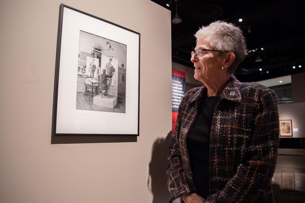 Karen Warrick stands next to a photo of painter Norman Rockwell painting a portrait of Abraham Lincoln which became “Lincoln the Railsplitter,” the painting that hung in her father’s bank, Lincoln Federal Savings. A collection and a reproduction of Rockwell’s painting are on display at the Northwest Museum of Arts and Culture as part of a Rockwell exhibit. Photographed Tuesday, Oct. 15, 2019. (Jesse Tinsley / The Spokesman-Review)