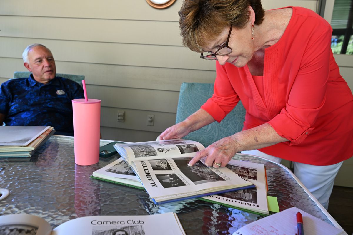 Margaret “Madge” Elmore looks through one of her high school yearbooks from Gonzaga Preparatory School on Thursday at her home in north Spokane. In the 1970s, she became part of the first class of girls to go to the all-boys school. Her husband, Mark, left, went to Gonzaga Prep as well.
