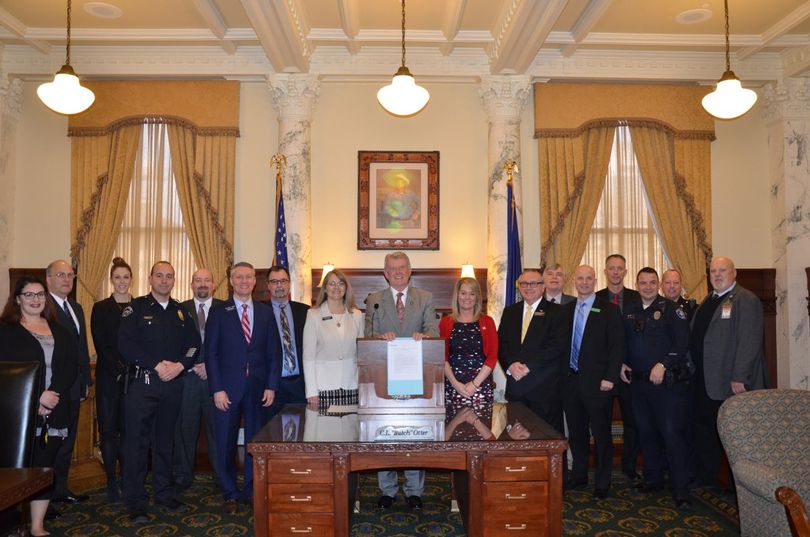 Idaho Gov. Butch Otter poses with supporters of HB 665, legislation updating Idaho's school threats law to cover social media and adding felony provisions when a deadly weapon is involved, after he signs it into law in his office on Friday, March 23, 2018. (State of Idaho)