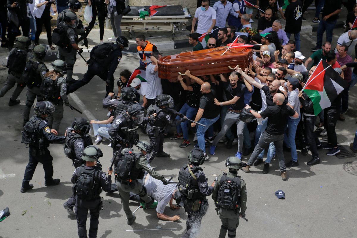Israeli police confront with mourners as they carry the casket of slain Al Jazeera veteran journalist Shireen Abu Akleh during her funeral in east Jerusalem, Friday, May 13, 2022. Abu Akleh, a Palestinian-American reporter who covered the Mideast conflict for more than 25 years, was shot dead Wednesday during an Israeli military raid in the West Bank town of Jenin.  (Maya Levin)