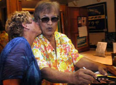 
Don Ho, right, gets a kiss from a fan after his nightly show at the Waikiki Beachcomber  in Honolulu. Schmoozing with fans keeps Ho's spirit young. Keeping with a tradition he started during the height of his popularity in the 1960s and '70s, he meets with every fan for pictures and autographs. 
 (Associated Press / The Spokesman-Review)