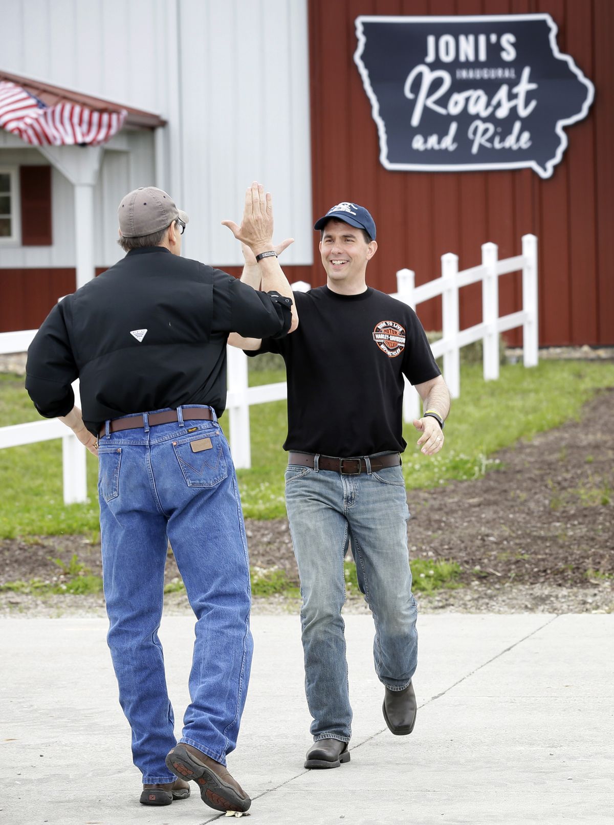 Wisconsin Gov. Scott Walker, right, greets GOP presidential candidate and former Texas Gov. Rick Perry before speaking Saturday at an event in Boone, Iowa. (Associated Press)