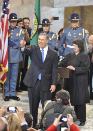 OLYMPIA -- Gov. Jay Inslee waves to the crowd in the Capitol Rotunda after being sworn in by state Chief Justice Barbara Madsen. (Jim Camden)