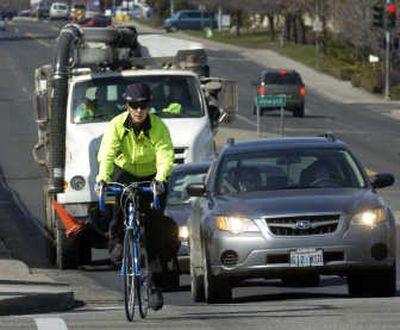
Barb Chamberlain maneuvers through Spokane traffic Thursday at the corner of Washington and Indiana. She bikes to work most days. 
 (Photos by DAN PELLE / The Spokesman-Review)