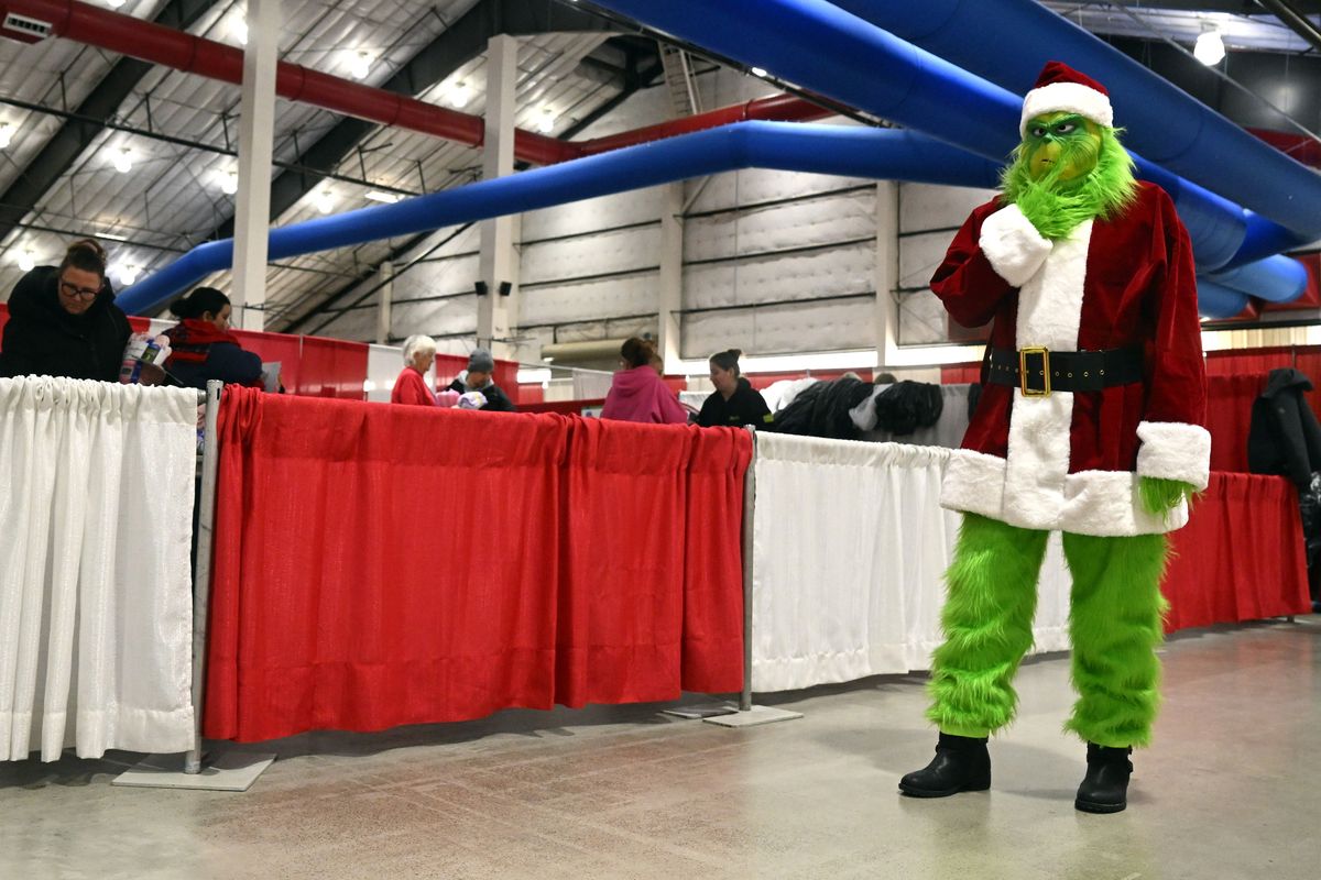 A former client dressed as the Grinch and roamed around the Christmas Bureau on Saturday while parents chose pajamas, toys and books in the exhibition buildings at the Spokane Fair and Expo Center in Spokane.  (Jesse Tinsley/THE SPOKESMAN-REVIEW)