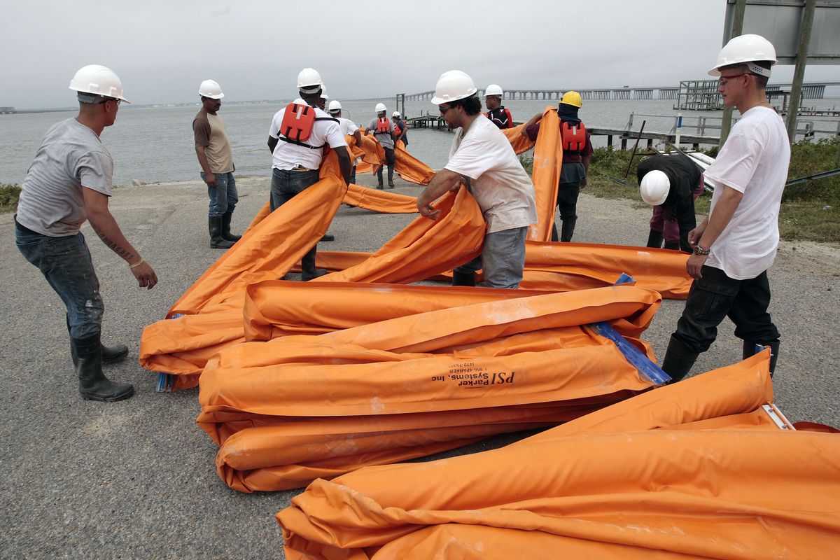 Workers load a boat with oil booms in Bay St. Louis, Miss., on Friday as they continue preparations to head off damage from an oil spill along the Gulf of Mexico coast. Associated Press photos (Associated Press photos)