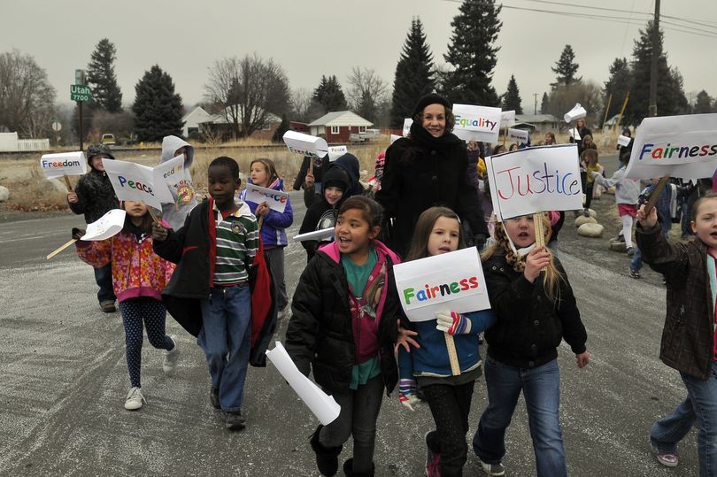 Students from Orchard Center Elementary School march down a street near the school Friday, during a celebration of Martin Luther King Day. The students made signs and performed a skit at an assembly. (Jesse Tinsley)
