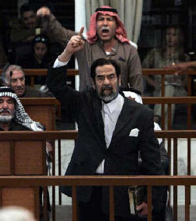 
Former Iraqi President Saddam Hussein, front center, and Barzan Ibrahim al-Tikriti berate the court during their trial in Baghdad on Monday. All of Saddam's defense team walked out of the courtroom in protest after the judge denied a motion to immediately delay proceedings. 
 (Associated Press / The Spokesman-Review)