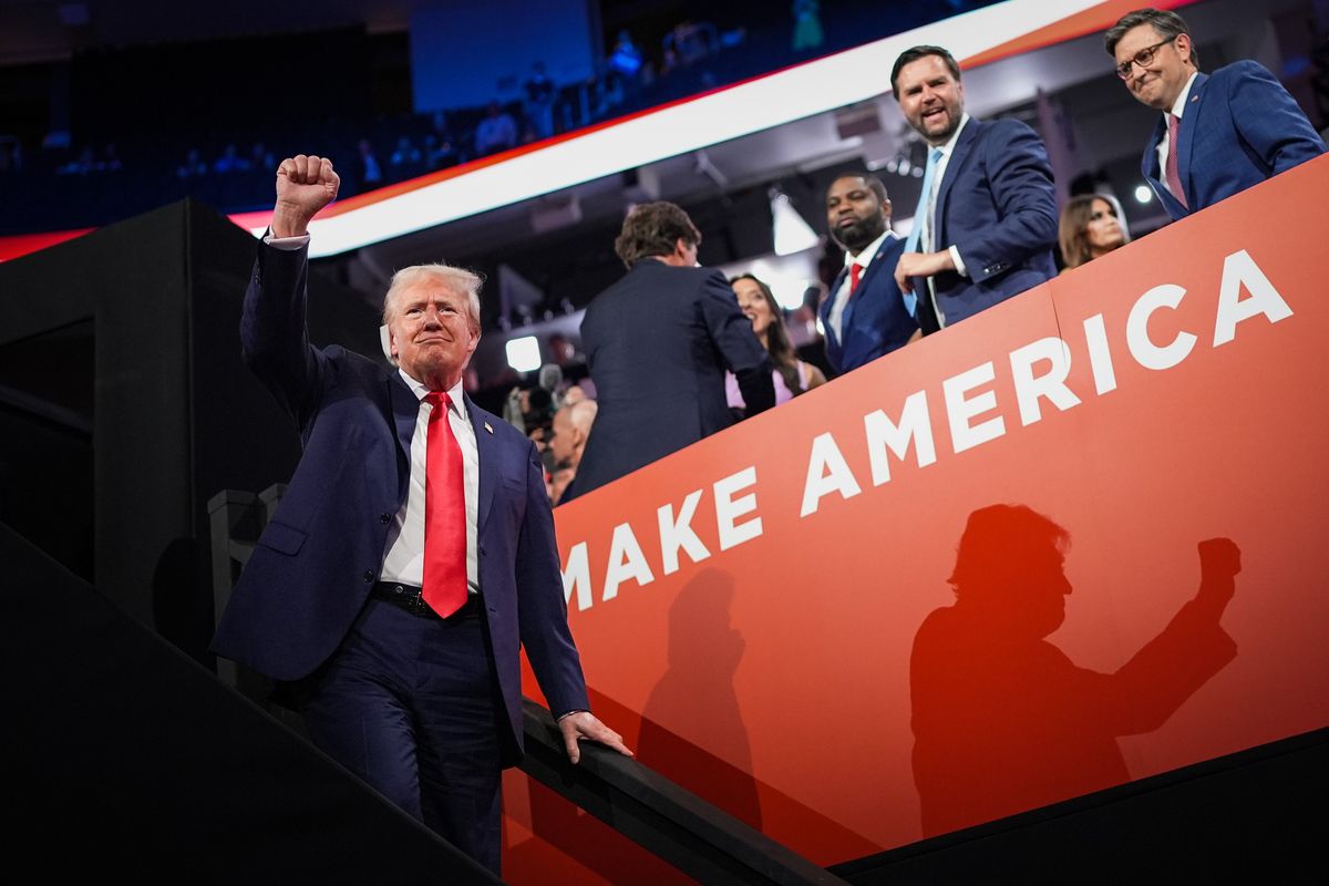 Republican presidential candidate and former President Donald Trump, with bandaged ear, gestures during the first day of the Republican National Convention at the Fiserv Forum on Monday in Milwaukee, Wisc. Second from right is Trump’s pick for running mate, Sen. J.D. Vance.  (Getty Images)