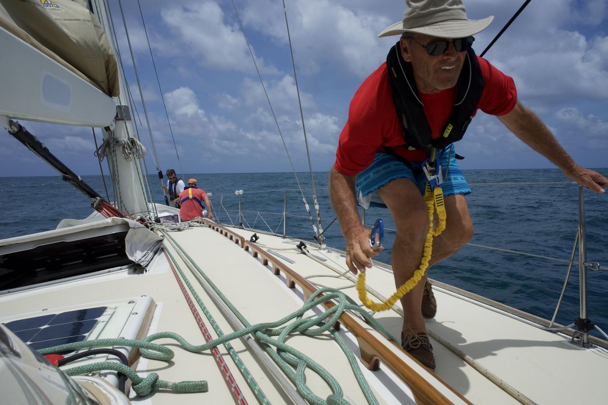 Rick Moran uses his safety harness attached to the boat, which keeps the sailors strapped to the boat. One slip could send him over the edge which at night could be deadly. (Will Campbell / The Spokesman-Review)