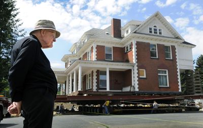 Father Paul Luger  spent most of Wednesday watching the Huetter Mansion begin its slow move 120 feet from it current location at Sharp and Addison to its new home across the street to the east. The building, which is over 100 years old, weighs 420 tons and is being rolled on 96 wheels.  (Dan Pelle / The Spokesman-Review)