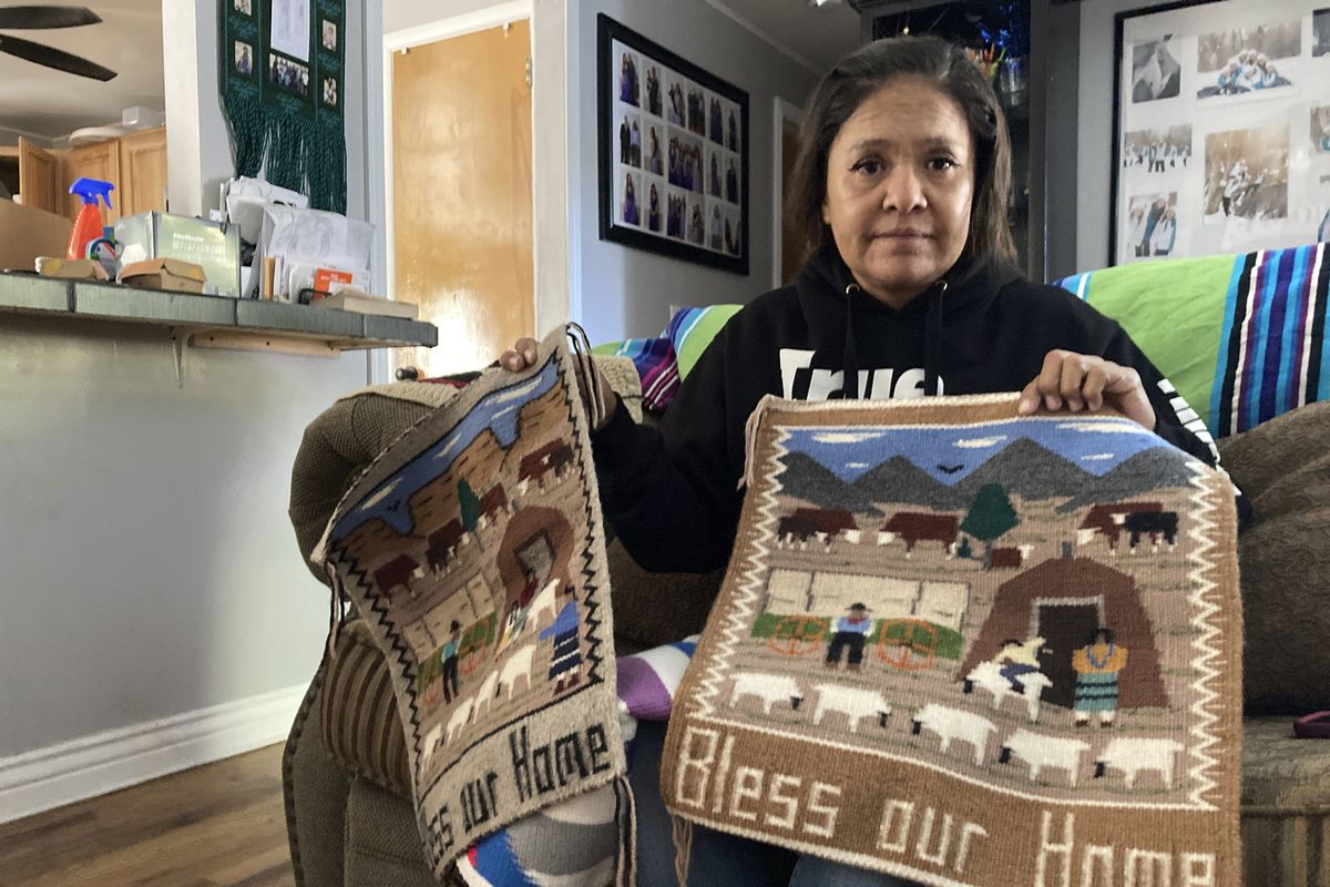 Seraphine Warren poses for a photo in her home in Tooele, Utah, on Sept. 23, 2021, with a rug made by her aunt, Navajo rug weaver Ella Mae Begay. Begay, 62, disappeared in June, one of thousands of missing Indigenous women across the U.S. The extensive coverage of the Gabby Petito case is renewing calls to also shine a spotlight on missing people of color.  (Lindsay Whitehurst)