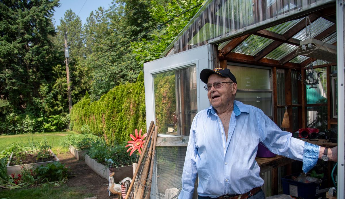 Former Navy veteran from the end of World War II and an avid gardener who perfected the art of composting and creating his own gardening soil, Bill Palmer laughs Monday while he stands by his greenhouse and modest garden in his Spokane Valley backyard.  (Jesse Tinsley/The Spokesman-Review)