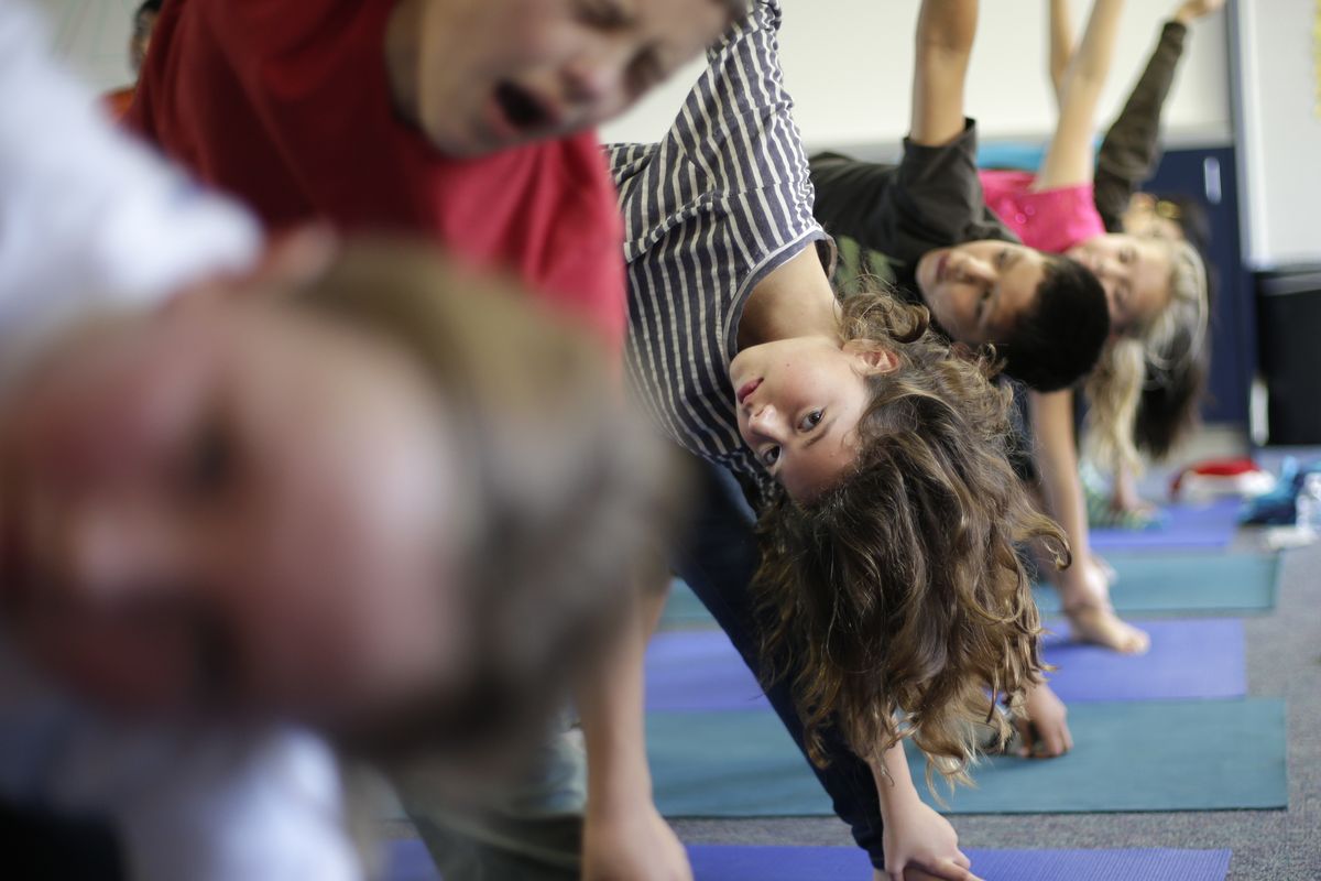 In this Dec. 11, 2012 picture, fourth grader Anna De La Fuente reaches holds a position during a yoga class at Capri Elementary School in Encinitas, Calif. Administrators of the Encinitas Union School District are treading softly as they pioneer what is believed to be the first district-wide yoga program of its kind, while trying to avoid a legal dispute over whether yoga is just exercise or an intrinsically spiritual practice. (Gregory Bull / Associated Press)