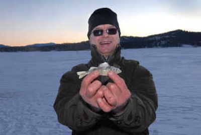 
North Idaho resident Dave Voelker is proud of his catch while ice fishing at Hayden Lake. Few anglers can hook a fish this small, he said. 
 (Brian Plonka / The Spokesman-Review)