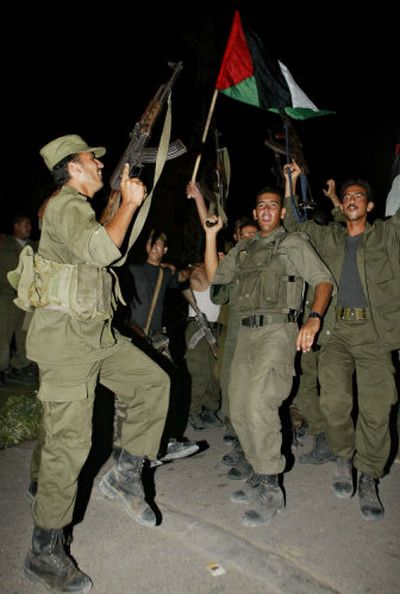 
Palestinian police officers celebrate as they wait in the town of Beit Lahiya to enter the Jewish settlement of Dugit, northern Gaza Strip, late Sunday. 
 (Associated Press / The Spokesman-Review)