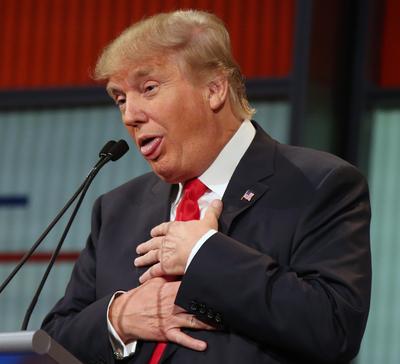 Donald Trump responds to fellow presidential contender Mike Huckabee’s closing remarks during the first debate Aug. 6 in Cleveland. (Associated Press)