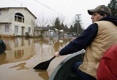 
Bert Carver paddles down the flooded street to the house he owns but has for sale in Centralia, Wash., on Wednesday. Associated Press
 (Associated Press / The Spokesman-Review)