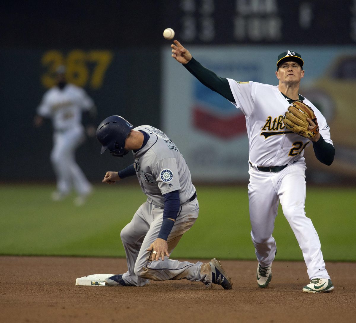 Oakland Athletics third baseman Matt Chapman  throws after forcing out Seattle’s Mitch Haniger  on a grounder by Kyle Seager, who was safe at first base during the fourth inning Tuesday in Oakland, Calif. (D. Ross Cameron / AP)