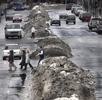 Pedestrian dodge huge snow berms in downtown Spokane, Wash. Wednesday January 7, 2009.  Spokane Mayor Mary Verner held a press conference to talk about how the city is handling the aftermath of record setting snowfall over the past several weeks.  CHRISTOPHER ANDERSON The Spokesman-Review (Christopher Anderson / The Spokesman-Review)