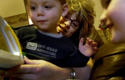 
Day-care provider Kim Banks holds 2-year-old Tanner Langley while he plays with a toy Monday at the Cozy Cottage in Coeur d'Alene. Dozens of Coeur d'Alene day-care workers have submitted to fingerprints and criminal background checks as the city's new child-care rules, among the most stringent in Idaho, take effect. 
 (Kathy Plonka / The Spokesman-Review)
