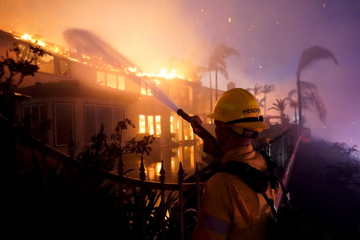 A firefighter works to put out a structure burning during a wildfire Wednesday in Laguna Niguel, Calif.  (Marcio J. Sanchez)