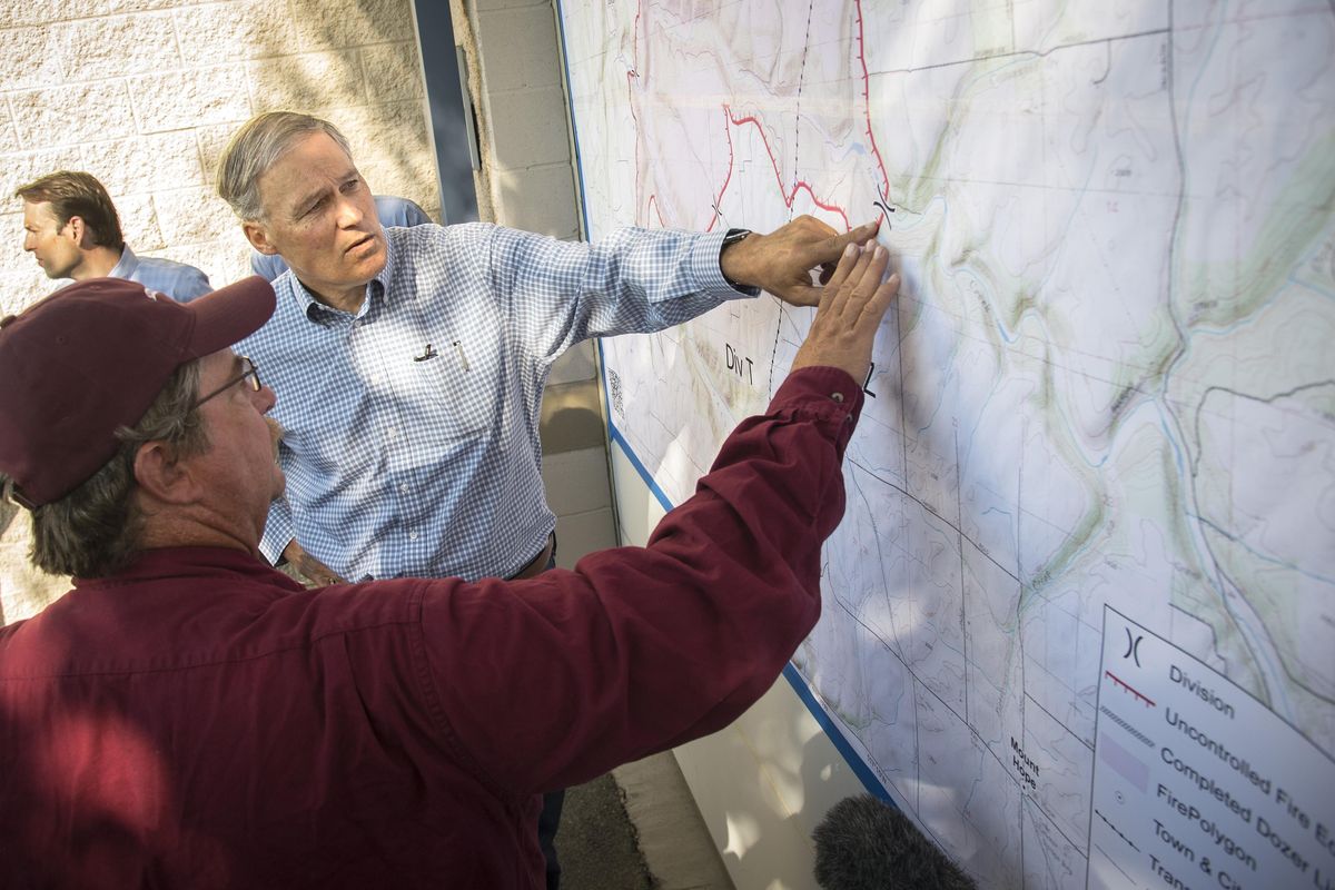 Nathan Rabe, incident commander for the Spokane Complex fires, gives Gov. Jay Inslee a fire briefing, Tuesday, Aug. 23, 2016, at the Spokane Fair and Expo Center in Spokane. (Colin Mulvany / The Spokesman-Review)