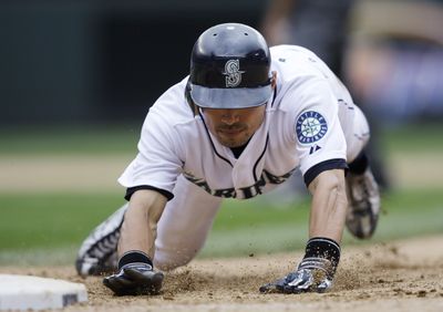 Ichiro Suzuki dives back to first base on a pickoff attempt.  (Associated Press / The Spokesman-Review)