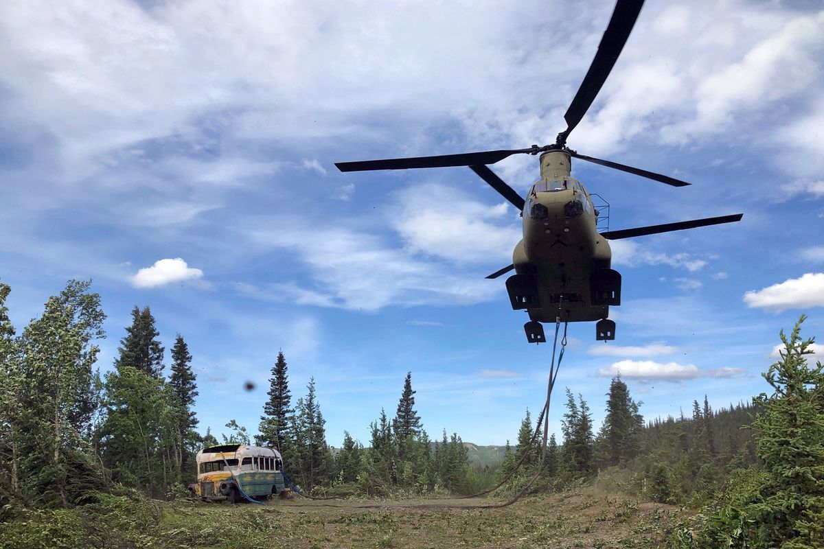 FILE - In this June 18, 2020, file photo released by the Alaska National Guard, Alaska Army National Guard soldiers use a CH-47 Chinook helicopter to removed an abandoned bus, popularized by the book and movie "Into the Wild," out of its location in the Alaska backcountry as part of a training mission. The bus that once lured people on sometimes deadly pilgrimages to Alaska's backcountry can now safely be viewed at the University of Alaska Fairbanks while it undergoes preservation work. The bus was moved to the University's Engineering facility in early Oct. 2021, while it's being prepared for outdoor display at the Museum of the North, Fairbanks television station KTVF reported.  (Sgt. Seth LaCount)
