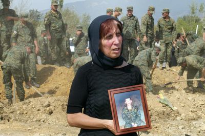 Anastasia Khaikashvili, holding a portrait of her missing son, Shmagi, cries Saturday in Tbilisi, Georgia, at a funeral ceremony for unknown soldiers killed during the Georgian-Russian conflict.  (Associated Press / The Spokesman-Review)
