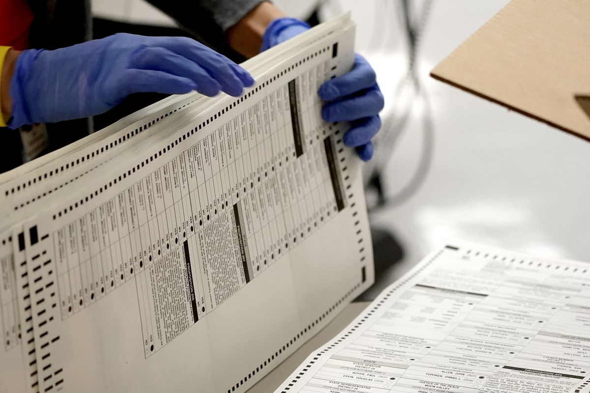 FILE - In this Nov. 4, 2020, file photo Maricopa County elections officials count ballots at the Maricopa County Recorder