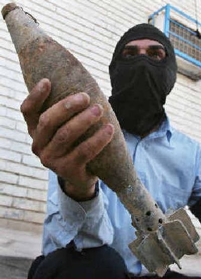 
A policeman shows a mortar shell found in Baghdad on Saturday.
 (The Spokesman-Review)