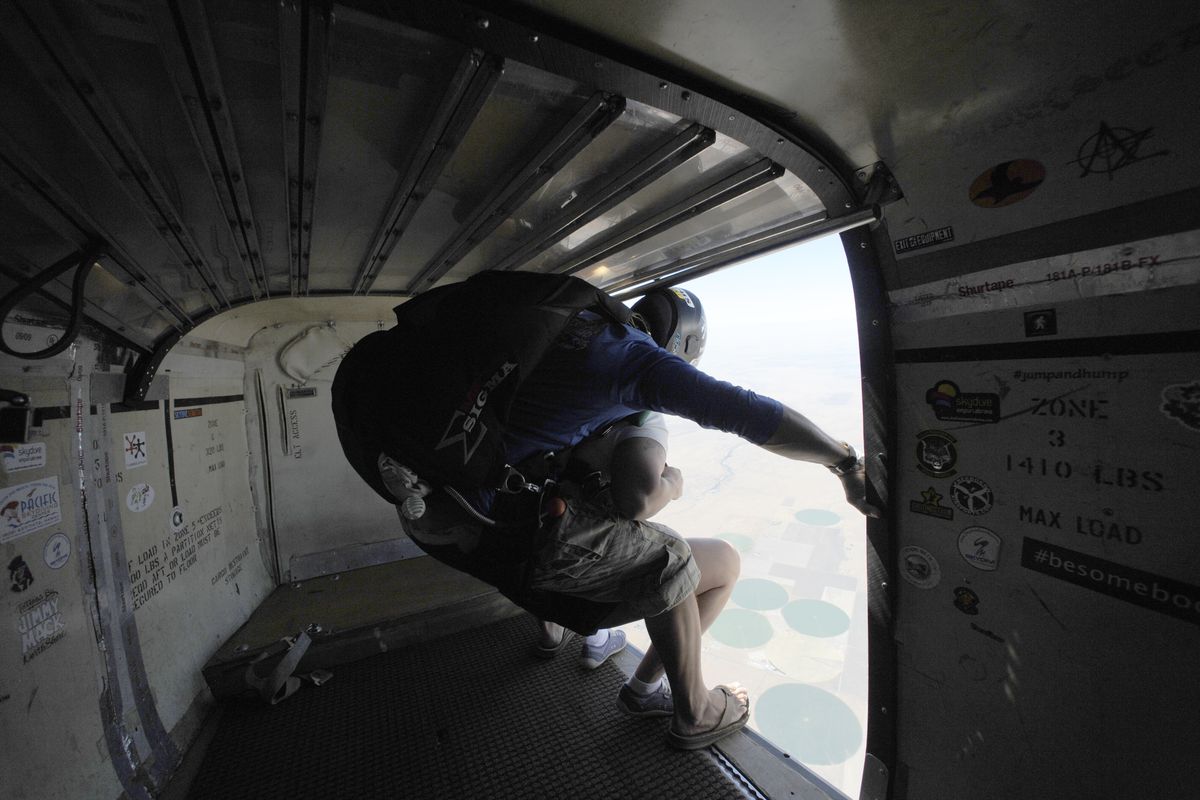 Skydiving instructor Rogers Stack stands in the doorway of the airplane with his client, Lisa Rivera of Richland, just before leaping two miles above Ritzville. (JESSE TINSLEY PHOTOS)
